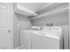 Bright laundry room featuring a washer and dryer, with shelving above at 5452 Tinker Toy Ave, Las Vegas, NV 89139
