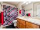 A bathroom with a patterned shower curtain, a wood vanity, and decorative accents at 574 Desert Tortoise Way, Mesquite, NV 89027