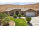 Charming single-story home features desert landscaping, a stone facade entry, and attached two car garage at 574 Desert Tortoise Way, Mesquite, NV 89027