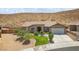 Charming single-story home features desert landscaping, a stone facade entry, and attached two car garage at 574 Desert Tortoise Way, Mesquite, NV 89027
