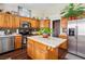 Bright kitchen with wood cabinets, stainless steel appliances, mosaic tile backsplash, and a center island at 574 Desert Tortoise Way, Mesquite, NV 89027