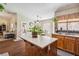 Kitchen island with wood cabinets, a white countertop, and a view of the kitchen sink and backyard at 574 Desert Tortoise Way, Mesquite, NV 89027