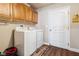 Functional laundry room featuring a washer, dryer, overhead cabinets, and wood-look flooring at 574 Desert Tortoise Way, Mesquite, NV 89027