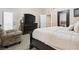 A primary bedroom with a sitting chair and TV offers a relaxing space to unwind at 574 Desert Tortoise Way, Mesquite, NV 89027