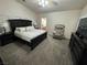 Spacious main bedroom with a large bed, cozy chair, and access to the bathroom at 574 Desert Tortoise Way, Mesquite, NV 89027