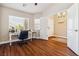 Office room features hardwood floors, bright windows, and a modern desk with a chandelier nearby at 574 Desert Tortoise Way, Mesquite, NV 89027
