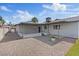 Rear view of property features a covered patio, desert landscaping, a small grassy area, and block fencing at 6553 Baywood Ave, Las Vegas, NV 89103