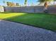 Private backyard with lush green grass and low-maintenance gravel landscaping at 6553 Baywood Ave, Las Vegas, NV 89103