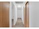 Hallway with carpet flooring and neutral walls connecting various rooms, with wood-colored doors at 6553 Baywood Ave, Las Vegas, NV 89103
