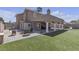 Landscaped backyard with a covered patio, lush lawn, and plenty of space for activities at 7197 Sixshooter Dr, Las Vegas, NV 89119