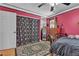 Vibrant bedroom with pink walls, complete with closet space and hardwood flooring at 7197 Sixshooter Dr, Las Vegas, NV 89119