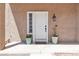 Inviting entryway featuring a white door, decorative plants, and stylish outdoor lighting at 7197 Sixshooter Dr, Las Vegas, NV 89119