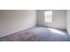 A bright bedroom features neutral carpet and a window at 7517 Crested Moon St, North Las Vegas, NV 89084