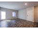 Spacious living room with wood floors, a bright window and a white entry door at 7517 Crested Moon St, North Las Vegas, NV 89084