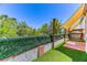 Spacious backyard with artificial grass, lush hedges, and a shaded patio area for entertaining at 7900 Dutch Canyon Ct, Las Vegas, NV 89131