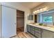 Bathroom with dual sinks, a large mirror, and a walk-in closet for storage at 7900 Dutch Canyon Ct, Las Vegas, NV 89131