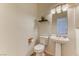 Cozy half bath featuring pedestal sink, wood look tile, and decorative accents at 7900 Dutch Canyon Ct, Las Vegas, NV 89131