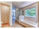 Bright bathroom with a soaking tub, a glass-enclosed shower, and wood-look floors at 7900 Dutch Canyon Ct, Las Vegas, NV 89131