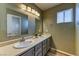 Bathroom featuring dual sinks, vanity with ample storage, and modern light fixture over light-colored walls at 7900 Dutch Canyon Ct, Las Vegas, NV 89131