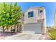 Two-story home with a two car garage, desert landscaping and a covered front porch with a porch swing at 7900 Dutch Canyon Ct, Las Vegas, NV 89131