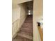 Carpeted staircase leading to a kitchen with modern white cabinetry and stainless steel appliances at 8149 Palace Monaco Ave, Las Vegas, NV 89117
