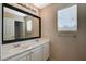Bathroom featuring a double sink vanity with a large mirror and a window for natural light at 8307 Fort Hallock Ave, Las Vegas, NV 89131