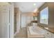 Bathroom features a soaking tub, separate shower, tiled floor, granite vanity and a bright window at 8307 Fort Hallock Ave, Las Vegas, NV 89131