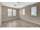 Spacious bedroom with neutral walls, wood floors, and three large windows at 8307 Fort Hallock Ave, Las Vegas, NV 89131
