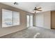 Bedroom with neutral walls, plush carpeting, balcony access, and a ceiling fan with light fixture at 8307 Fort Hallock Ave, Las Vegas, NV 89131