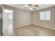 Bright bedroom boasts wood-look floors, a ceiling fan, a closet, and an open door to another room at 8307 Fort Hallock Ave, Las Vegas, NV 89131