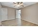 Bedroom features wood-look floors, ceiling fan, and ensuite bathroom entrance with an additional door at 8307 Fort Hallock Ave, Las Vegas, NV 89131