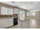 Well-lit kitchen featuring tile backsplash, granite countertops, and stainless-steel appliances at 8307 Fort Hallock Ave, Las Vegas, NV 89131
