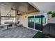 Enjoy the backyard's covered patio with ceiling fans, stone flooring, and room for outdoor furniture at 8316 Maplestar Rd, Las Vegas, NV 89128
