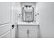 Modern bathroom has a mirror, white sink, cabinet and dark hardware at 8316 Maplestar Rd, Las Vegas, NV 89128