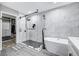 Luxurious bathroom with a glass-enclosed shower, soaking tub, and marble-style tiling at 8316 Maplestar Rd, Las Vegas, NV 89128