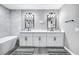 Elegant bathroom with double vanity, modern lighting, a soaking tub, and stylish gray walls at 8316 Maplestar Rd, Las Vegas, NV 89128