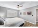 Comfortable bedroom with a ceiling fan, shuttered windows, and two framed artworks on the light gray walls at 8316 Maplestar Rd, Las Vegas, NV 89128