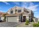 Inviting two-story home with a neutral stucco, tile roof, and paved driveway and desert landscaping at 8316 Maplestar Rd, Las Vegas, NV 89128