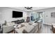 A modern living room with neutral colors, a large TV, and sliding glass doors to the backyard at 8316 Maplestar Rd, Las Vegas, NV 89128