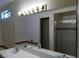 Bathroom with a large mirror, bright vanity lights, and a glass shower door at 8332 Shore Breeze Dr, Las Vegas, NV 89128
