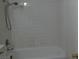 Shower and tub with a white tile surround and silver fixtures at 8332 Shore Breeze Dr, Las Vegas, NV 89128