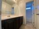 Bathroom featuring a large mirror, dark cabinets, and tile flooring at 8566 Bright Bush St, Las Vegas, NV 89131