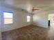 Bright living room featuring tile flooring, ceiling fan, and two large windows at 8566 Bright Bush St, Las Vegas, NV 89131