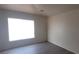 This bedroom features a window for natural light and dark wood-look flooring at 8695 Canfield Canyon Ave, Las Vegas, NV 89178