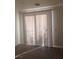 Living room showcasing patio doors with vertical blinds and laminate flooring at 8695 Canfield Canyon Ave, Las Vegas, NV 89178