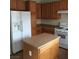 Kitchen with wood cabinets, island and white appliances at 8749 Brilliant Star Dr, Las Vegas, NV 89178