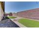 Landscaped backyard featuring artificial grass, gravel accents, and a brick perimeter wall for privacy at 9120 Parkstone Ave, Las Vegas, NV 89178