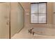 Bright bathroom featuring a soaking tub and frosted glass shower at 9120 Parkstone Ave, Las Vegas, NV 89178
