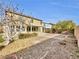 Backyard with small trees, shrubs, brick edging, rock groundcover, and covered patio at 9609 Rolling Thunder Ave, Las Vegas, NV 89148