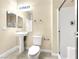 Well-lit bathroom includes pedestal sink, toilet, shower, and vanity mirror with recessed lighting at 9609 Rolling Thunder Ave, Las Vegas, NV 89148